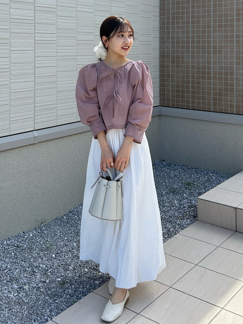 ホワイト系のバッグ、ピンク系のシャツ/ブラウス、ホワイト系のチューブトップを着用したレディースの春コーディネートの2枚目の写真