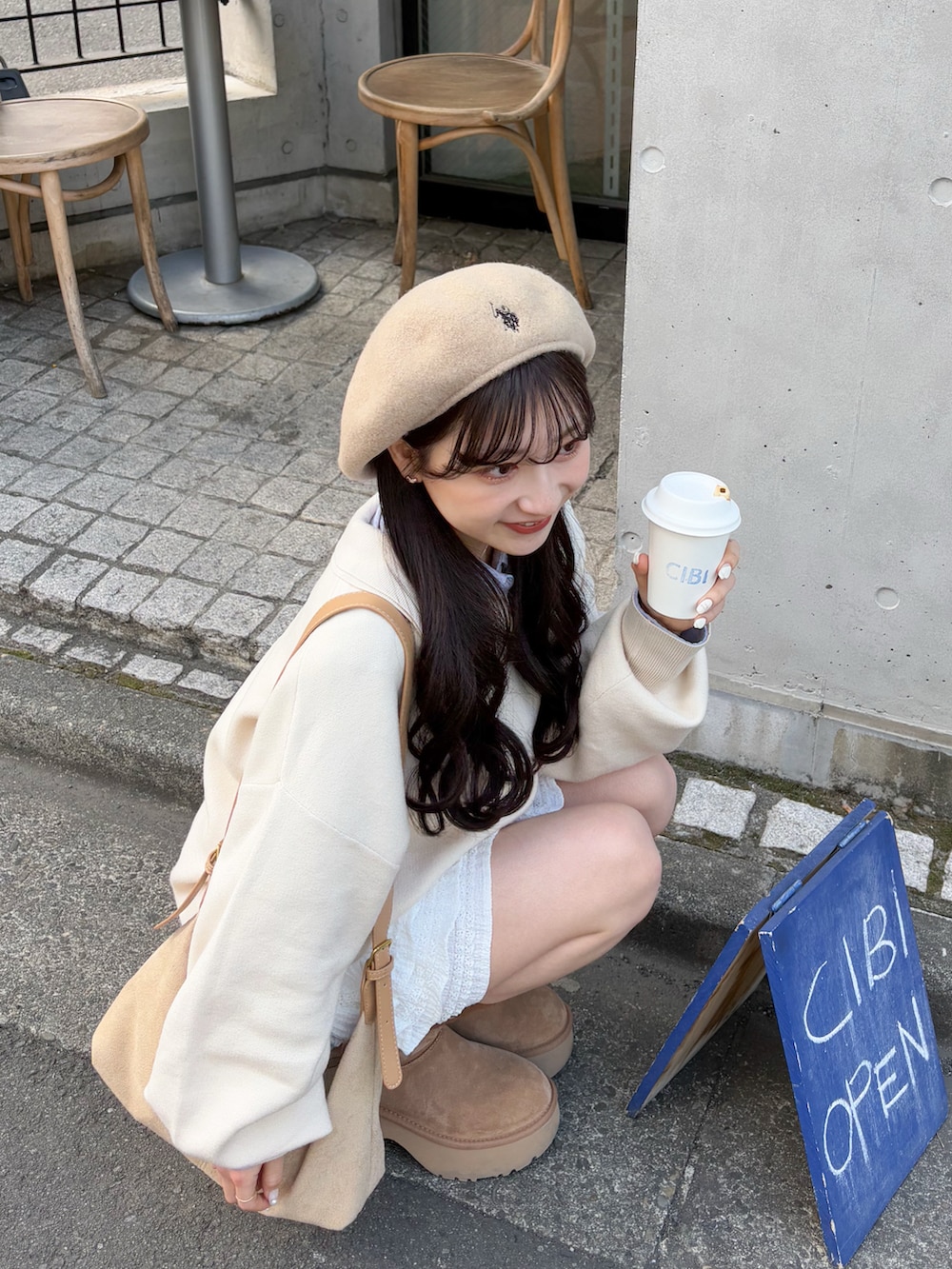 ホワイト系のニット/セーター、ベージュ系のショルダーバッグ、ホワイト系のスカートを着用したレディースの春コーディネートの2枚目の写真