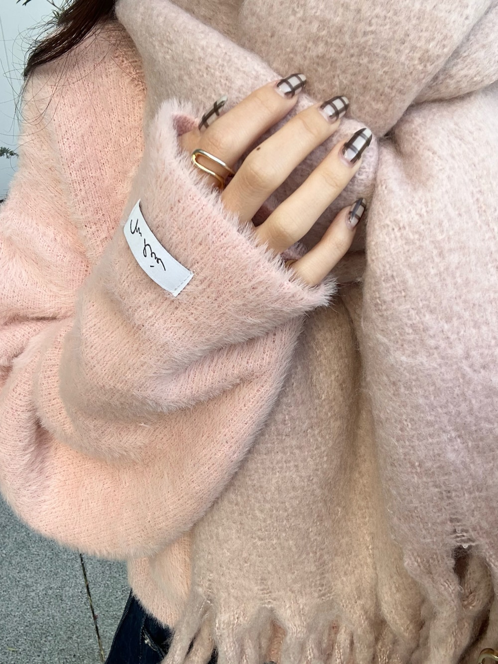 ブルー系のデニムパンツ、ピンク系のニット/セーター、ホワイト系のショルダーバッグを着用したレディースの冬コーディネートの5枚目の写真