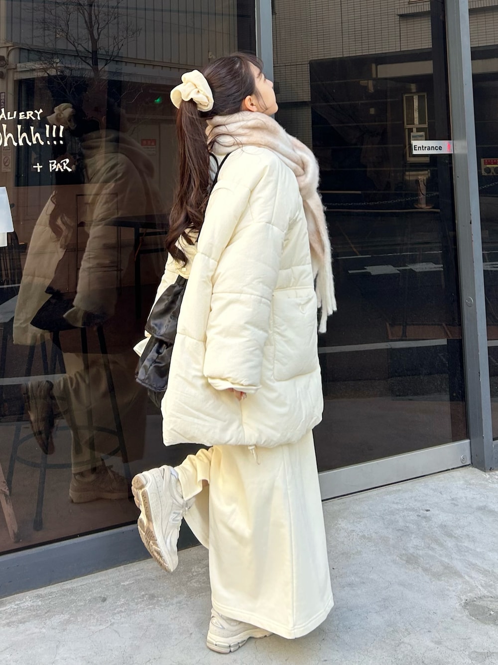 グレー系のスニーカー、ホワイト系のワンピース、ホワイト系のダウンジャケット/コートを着用したレディースの冬コーディネートの3枚目の写真