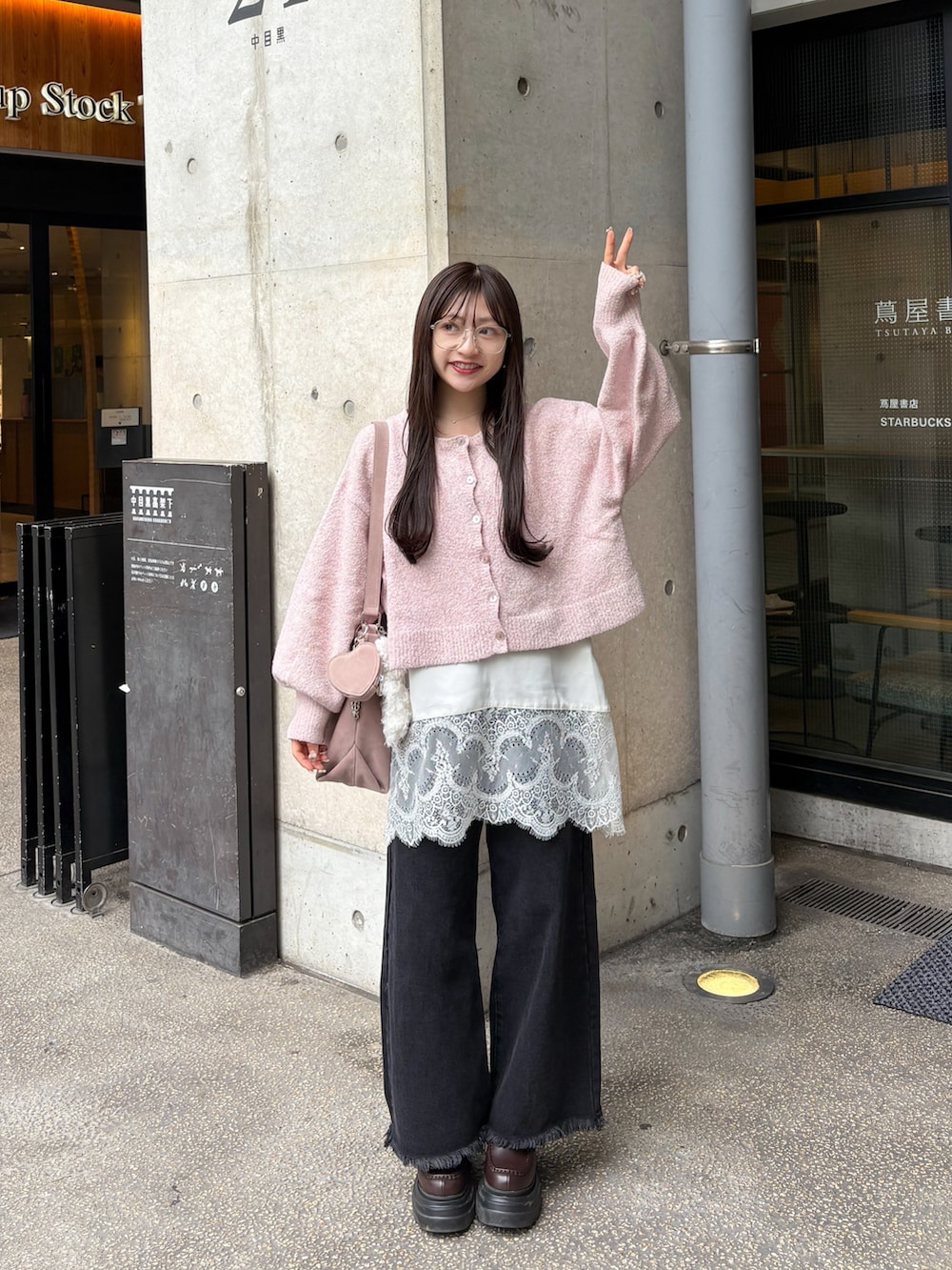 ホワイト系のキャミソール、ブラック系のデニムパンツ、ピンク系のショルダーバッグを着用したレディースの春コーディネートの3枚目の写真