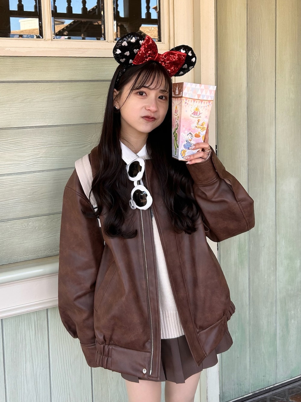 ホワイト系のニット/セーター、ブラウン系のスカート、ブラウン系のブルゾンを着用したレディースの冬コーディネートの3枚目の写真