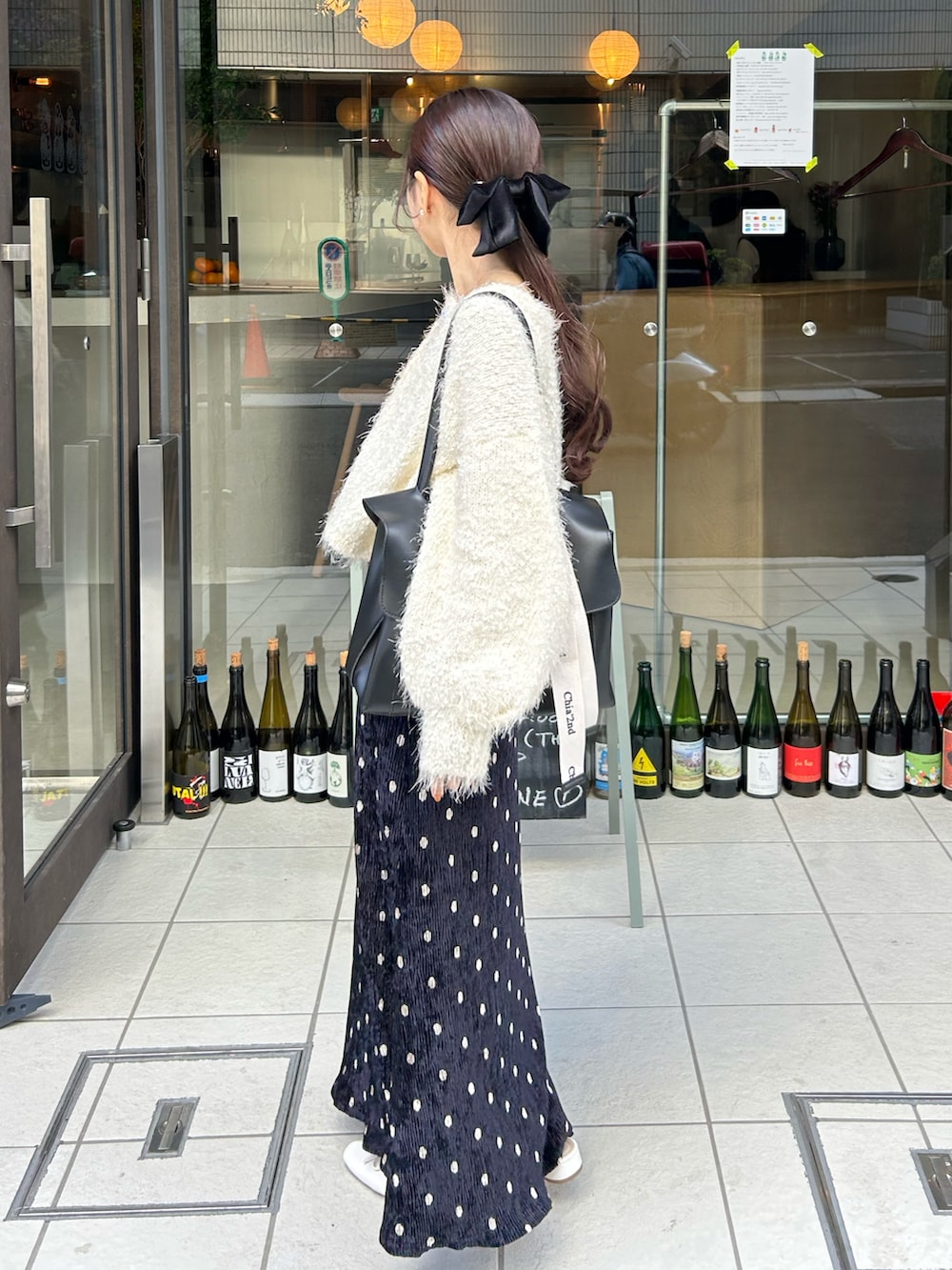 ホワイト系のカーディガン/ボレロ、ブラック系のショルダーバッグ、ホワイト系のサンダルを着用したレディースの秋コーディネートの2枚目の写真