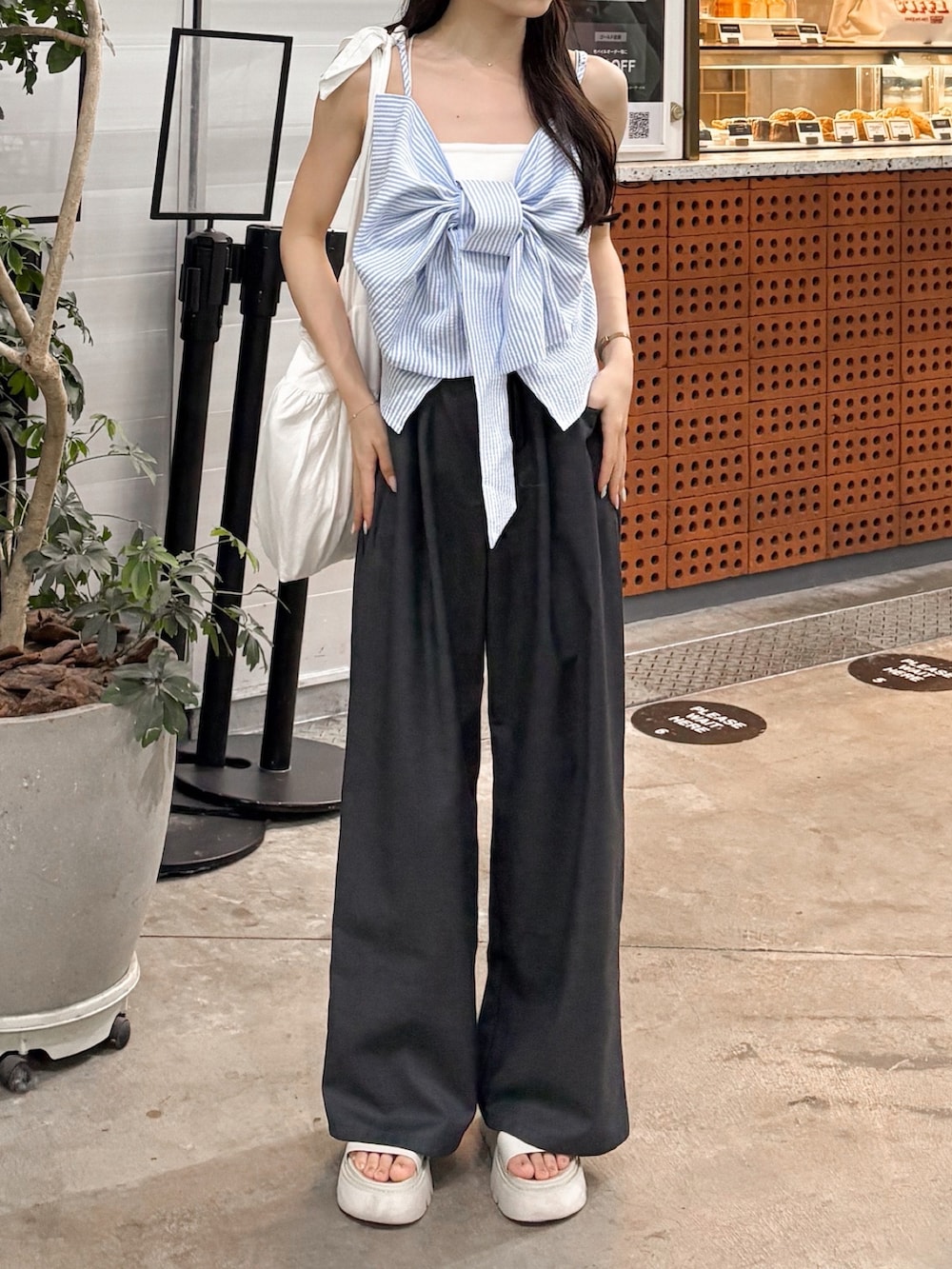 グレー系のその他パンツ、ホワイト系のサンダル、ブルー系のトップスを着用したレディースの夏コーディネートの3枚目の写真