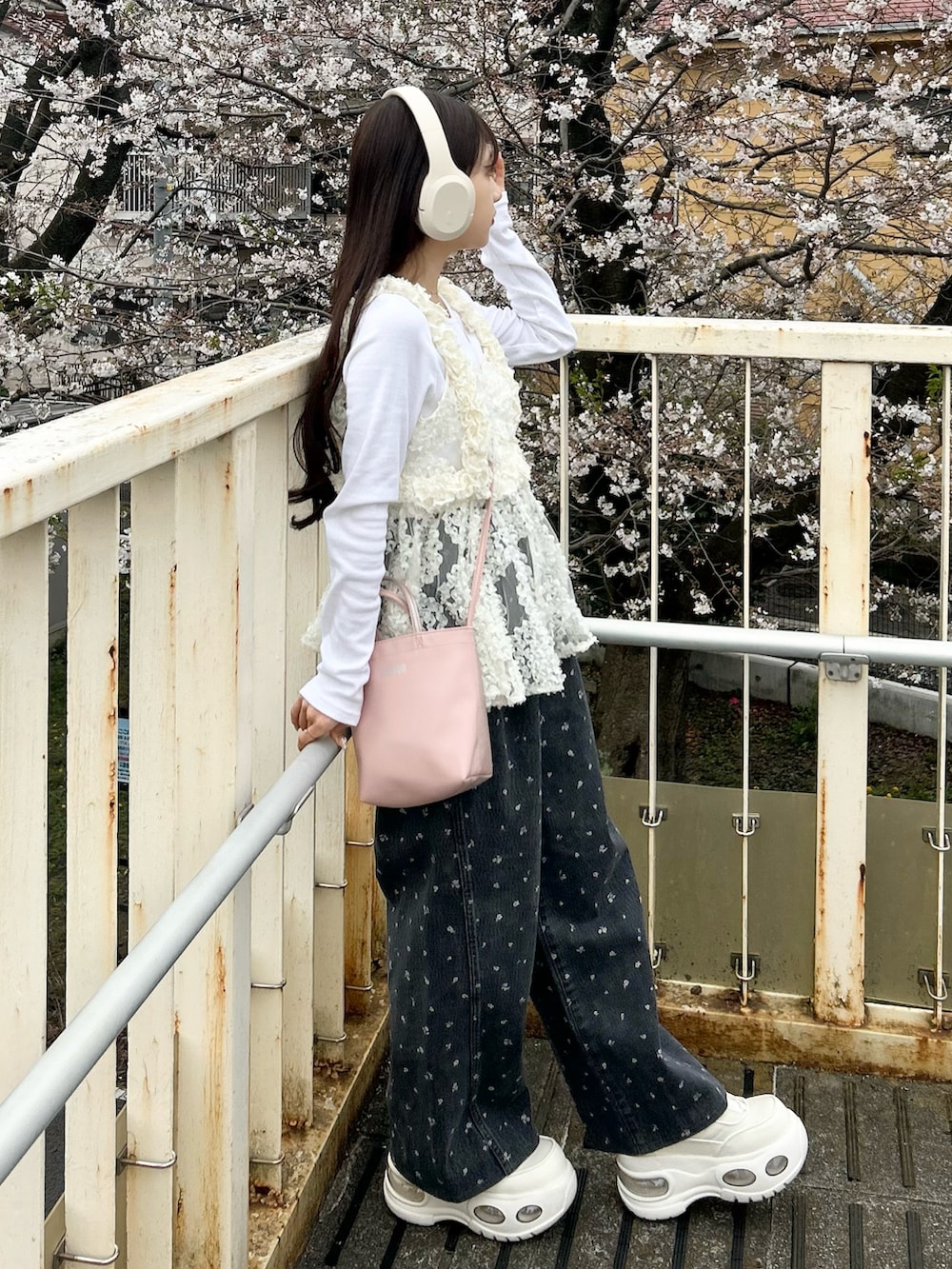 ホワイト系のスニーカー、ブラック系のデニムパンツ、ホワイト系のキャミソールを着用したレディースの春コーディネートの3枚目の写真