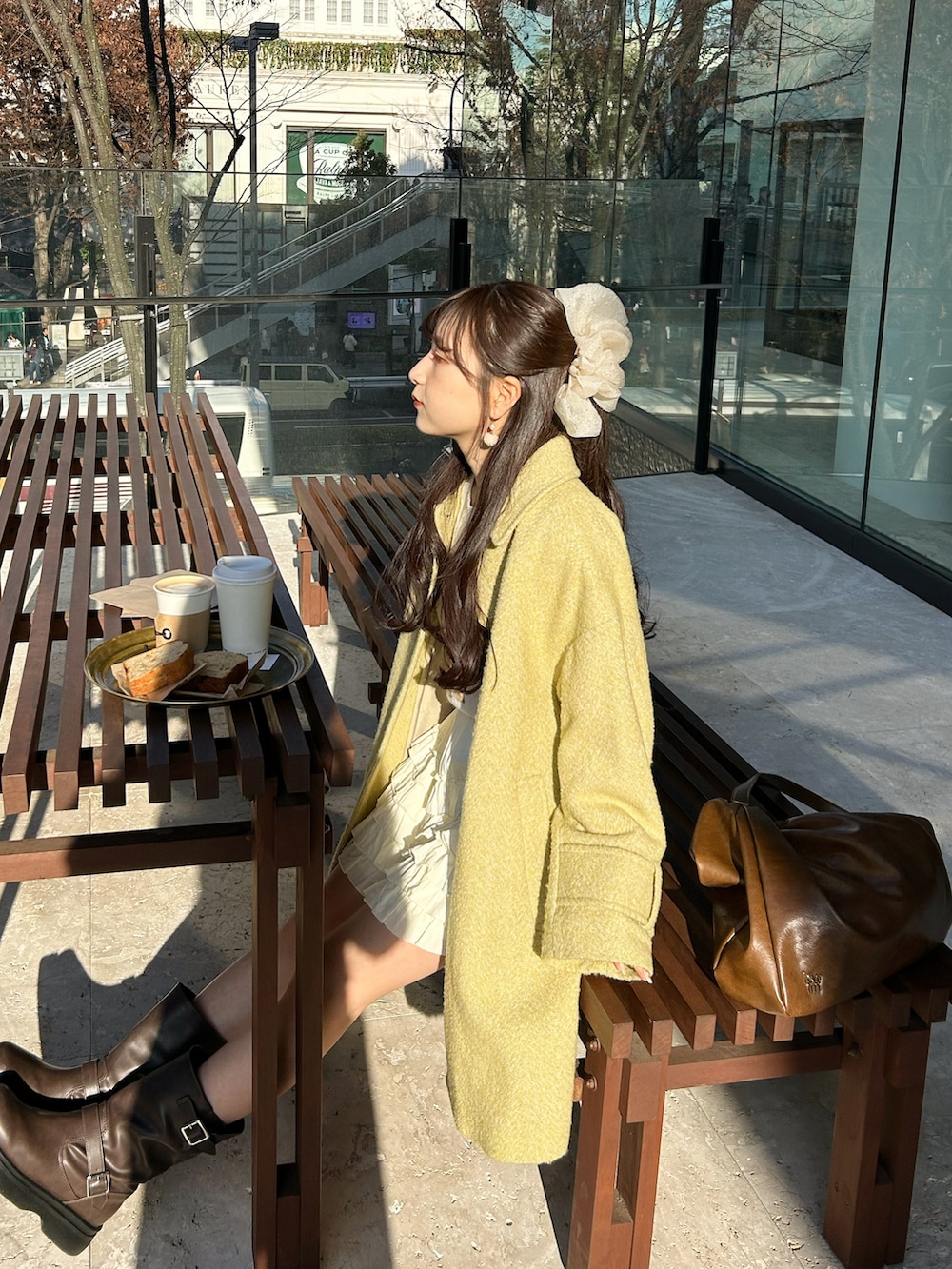 ブラウン系のブーツ、イエロー系のその他アウター、ブラウン系のショルダーバッグを着用したレディースの冬コーディネートの3枚目の写真