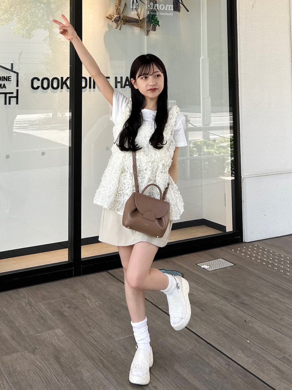 ブラウン系のバッグ、ホワイト系のキャミソール、ホワイト系のTシャツ/カットソーを着用したレディースの春コーディネートの2枚目の写真