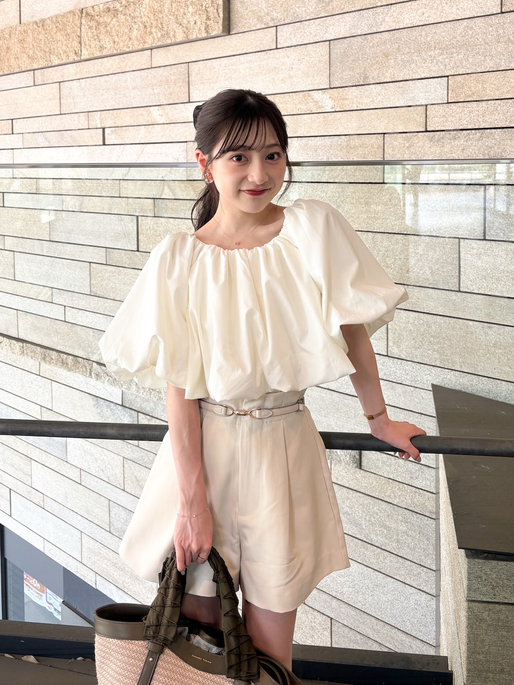 ベージュ系のサンダル、ホワイト系のシャツ/ブラウス、グリーン系のハンドバッグを着用したレディースの夏コーディネートの3枚目の写真