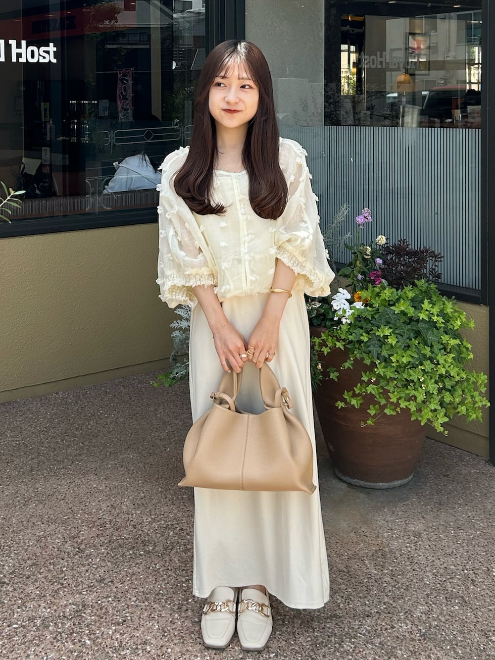 ベージュ系のバッグ、ホワイト系のローファー、ホワイト系のシャツ/ブラウスを着用したレディースの春コーディネートの2枚目の写真