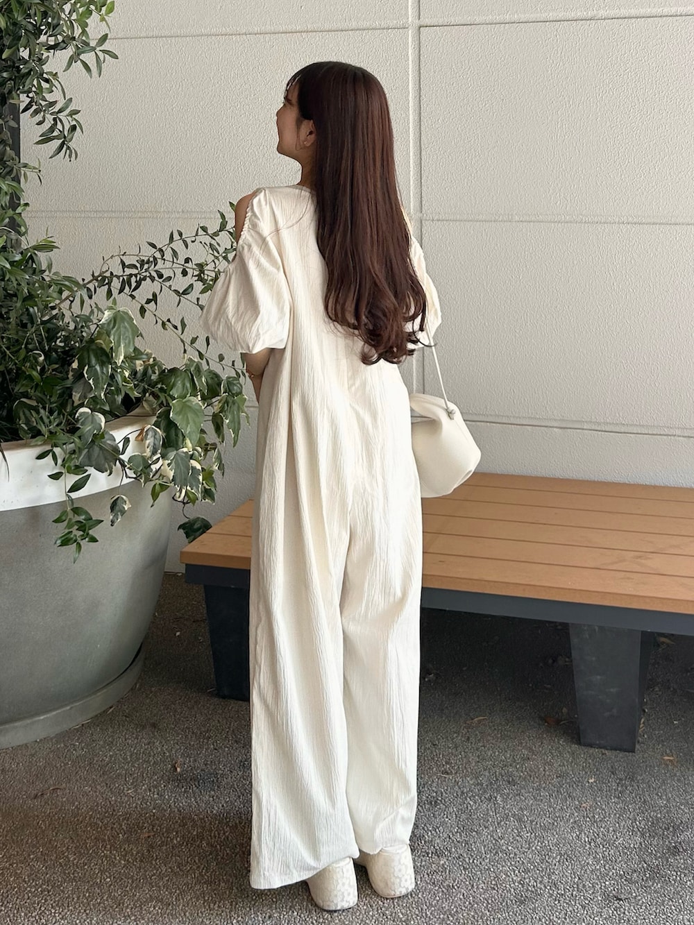 ホワイト系のつなぎ/オールインワン、ベージュ系のバッグ、ホワイト系のサンダルを着用したレディースの春コーディネートの4枚目の写真