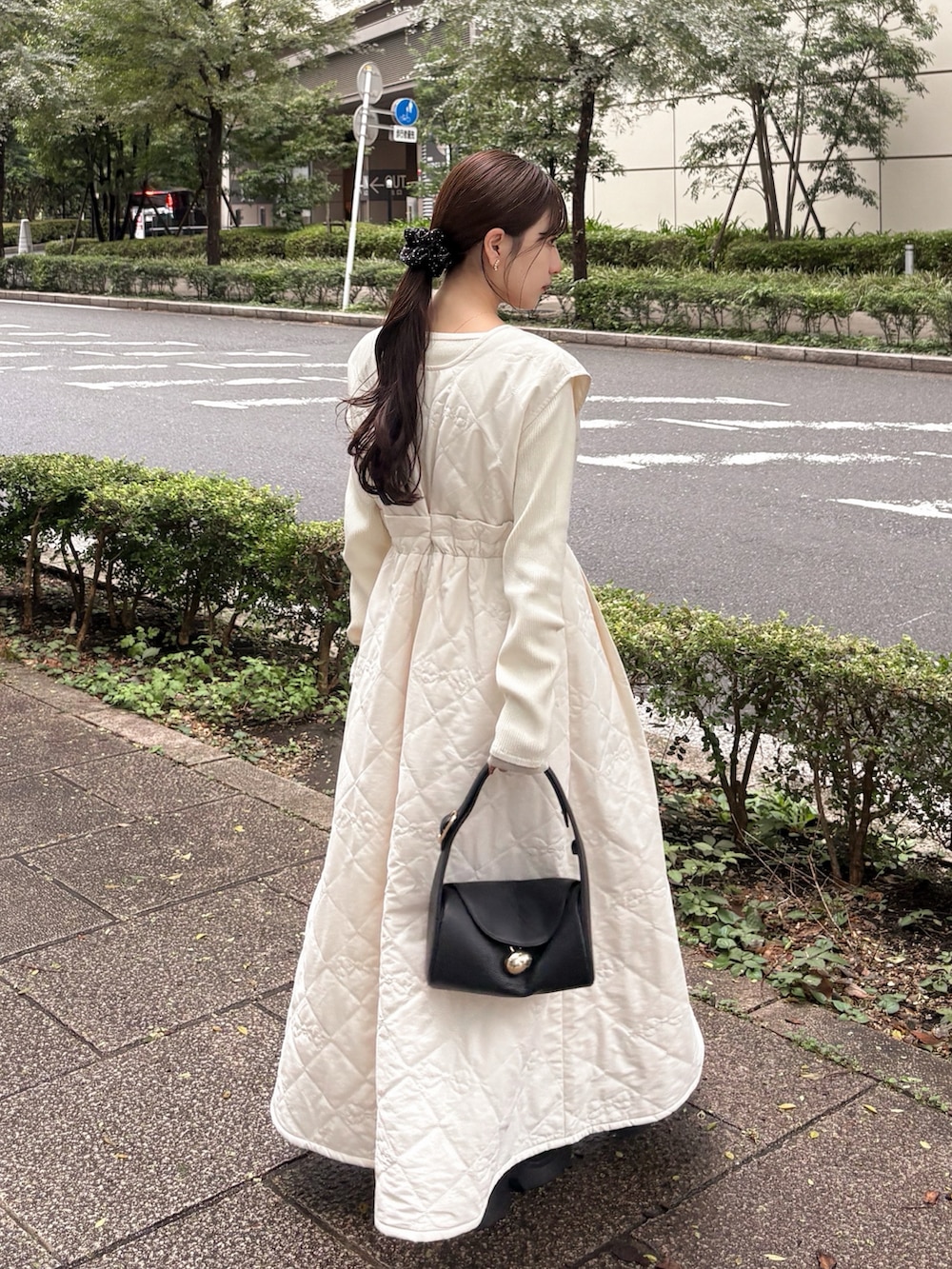 ホワイト系のニット/セーター、ブラック系のテーラードジャケット、ブラック系のブーツを着用したレディースの秋コーディネートの2枚目の写真