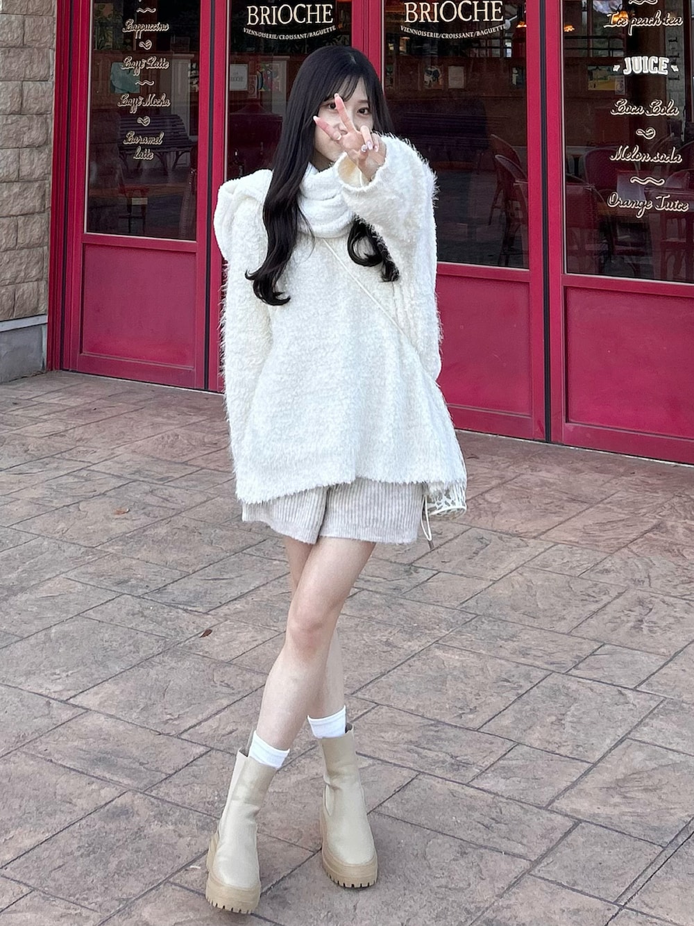 ホワイト系のカーディガン/ボレロ、ベージュ系のブーツ、ベージュ系のショルダーバッグを着用したレディースの冬コーディネートの4枚目の写真