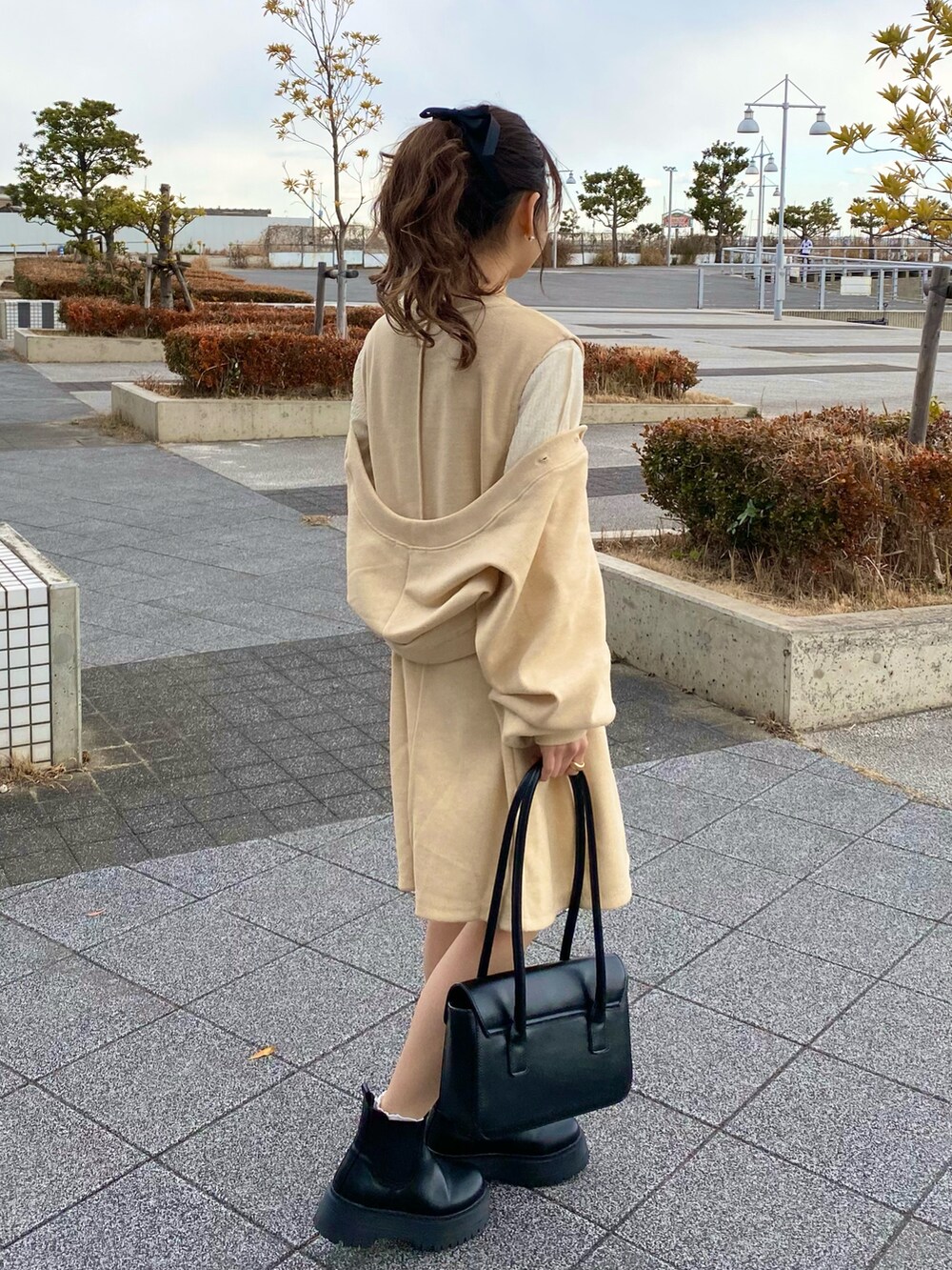 ブラック系のハンドバッグ、ホワイト系のTシャツ/カットソー、ホワイト系のカーディガン/ボレロを着用したレディースの冬コーディネートの2枚目の写真