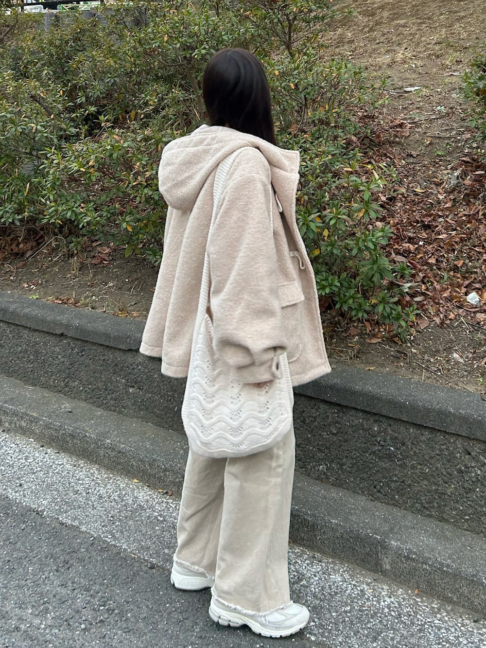 ベージュ系のデニムパンツ、ホワイト系のダッフルコート、ホワイト系のカーディガン/ボレロを着用したレディースの冬コーディネートの5枚目の写真