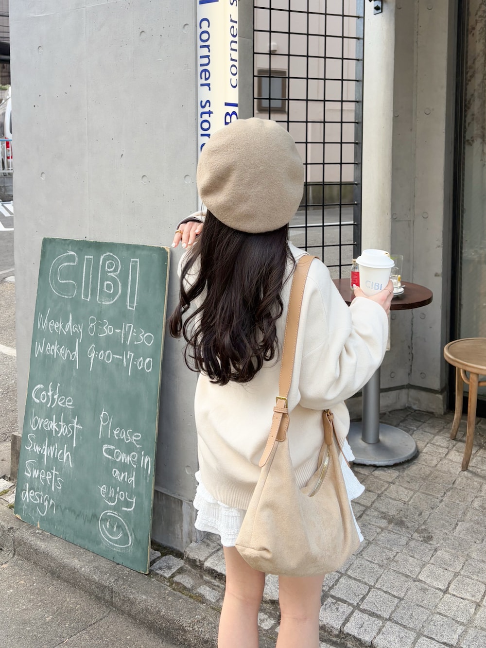 ホワイト系のニット/セーター、ベージュ系のショルダーバッグ、ホワイト系のスカートを着用したレディースの春コーディネートの4枚目の写真