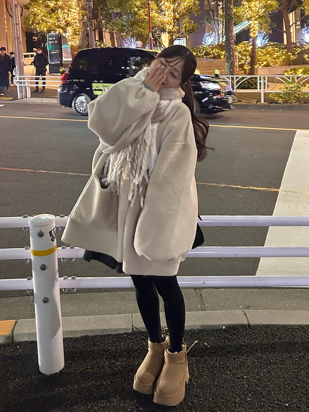 ブラック系のバッグ、ベージュ系のブーツ、ホワイト系のその他アウターを着用したレディースの冬コーディネートの2枚目の写真