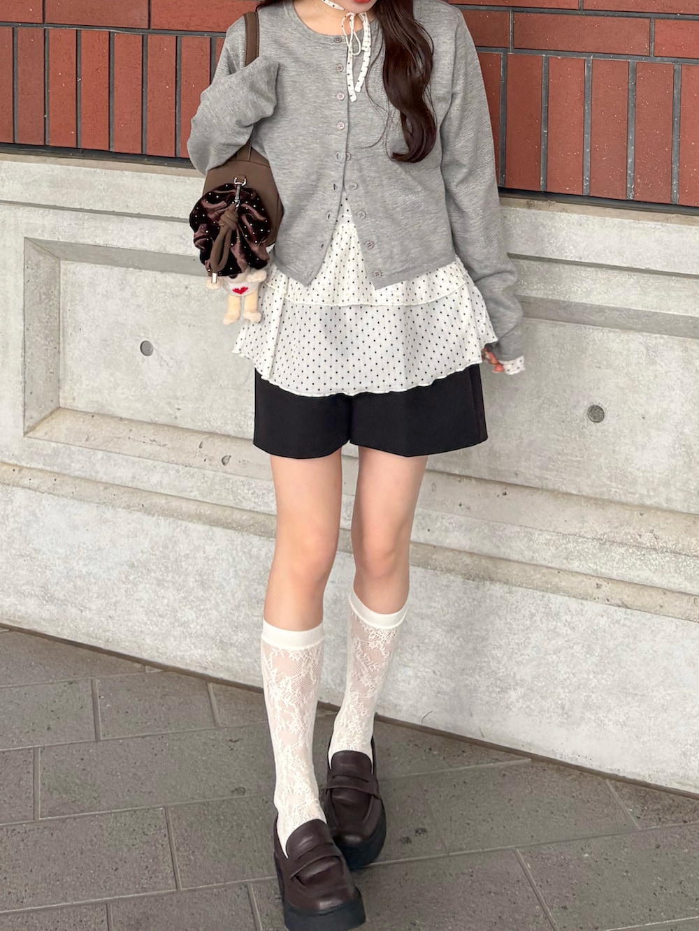 ホワイト系のTシャツ/カットソー、グレー系のカーディガン/ボレロ、ブラウン系のローファーを着用したレディースの秋コーディネートの3枚目の写真