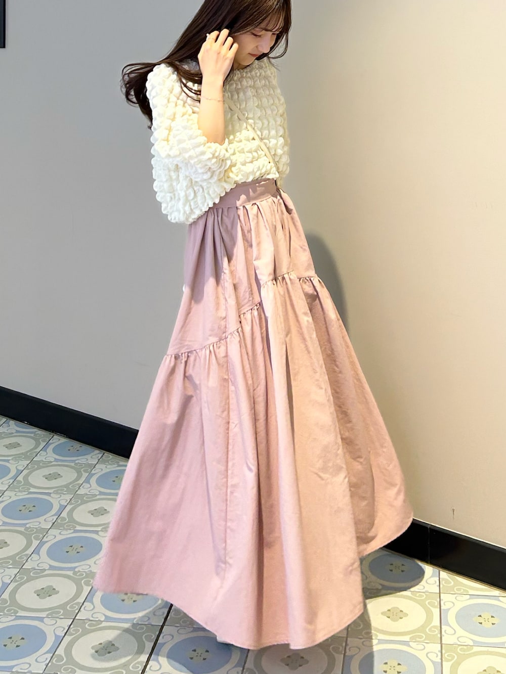 ホワイト系のショルダーバッグ、ピンク系のスカート、ホワイト系のTシャツ/カットソーを着用したレディースの春コーディネートの4枚目の写真