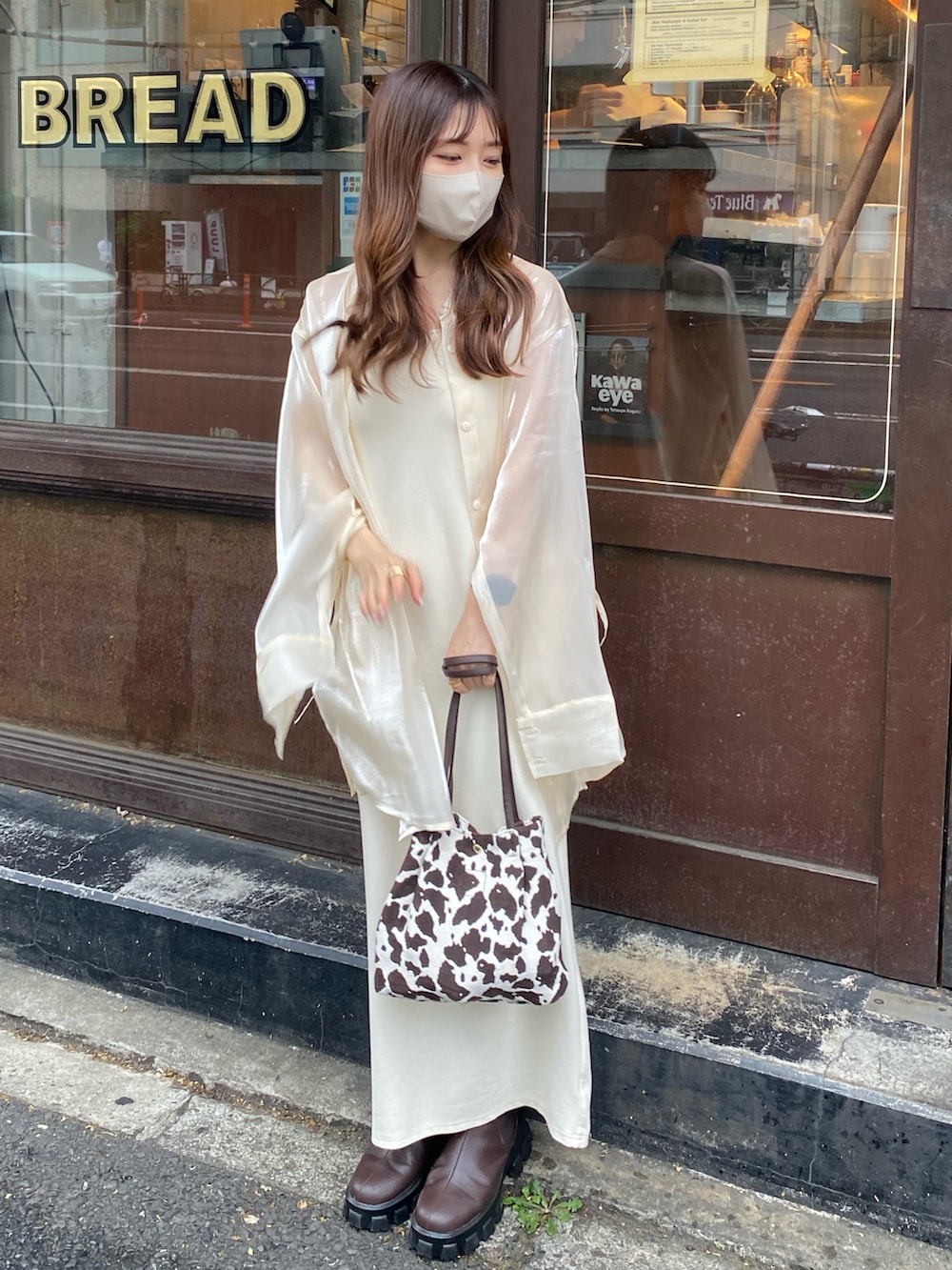 ホワイト系のワンピース、ブラウン系のハンドバッグ、ホワイト系のシャツ/ブラウスを着用したレディースの秋コーディネートの3枚目の写真