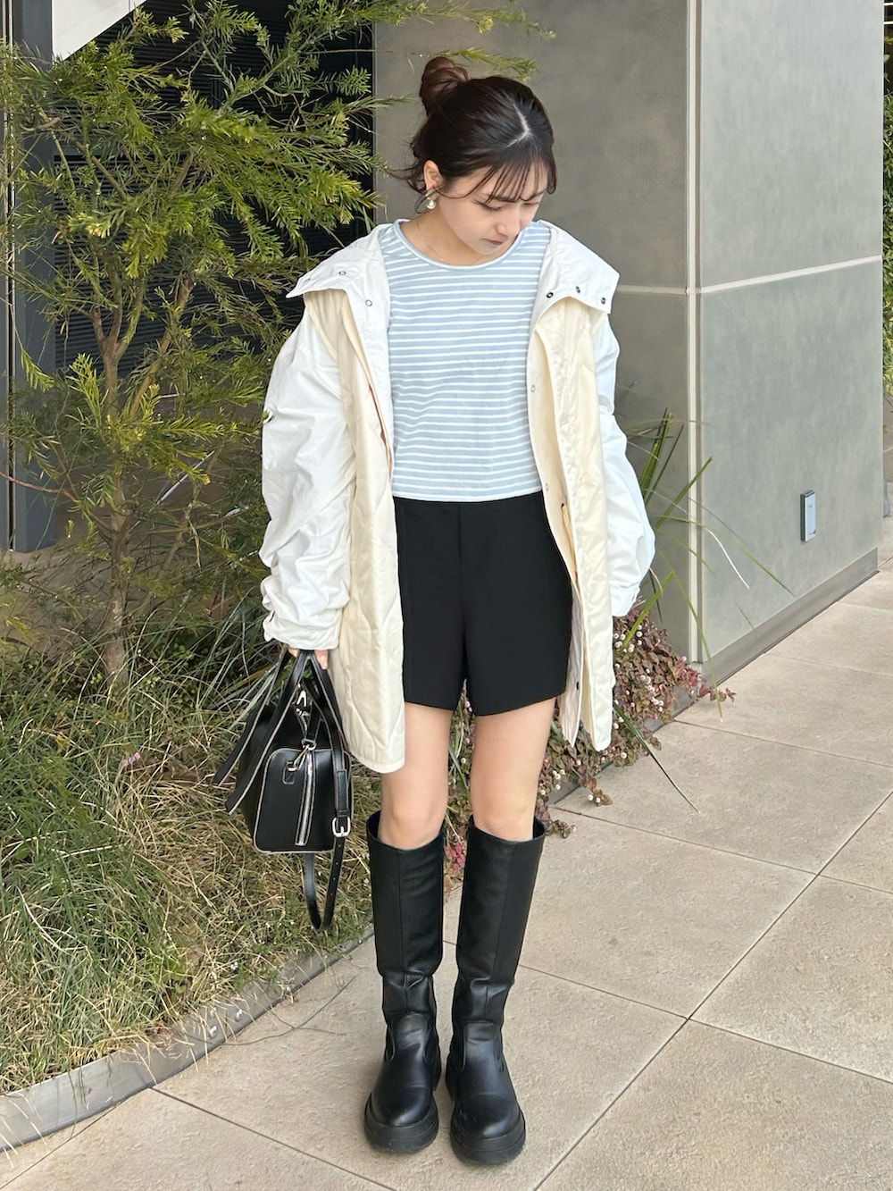 ブラック系のブーツ、ブルー系のTシャツ/カットソー、ホワイト系のその他アウターを着用したレディースの春コーディネートの4枚目の写真