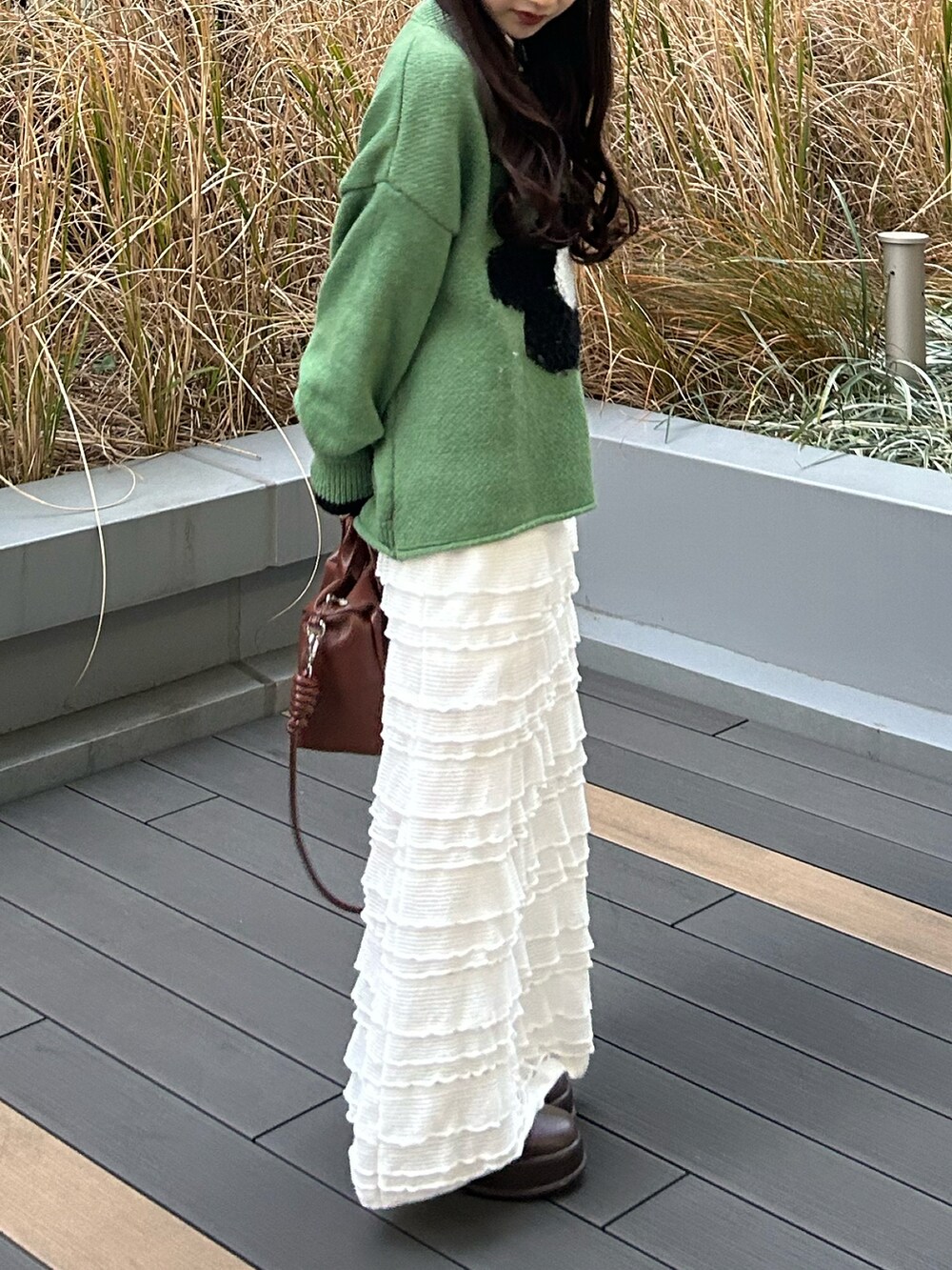 ブラウン系のボストンバッグ、ベージュ系のダッフルコート、ブラウン系のブーツを着用したレディースの冬コーディネートの4枚目の写真