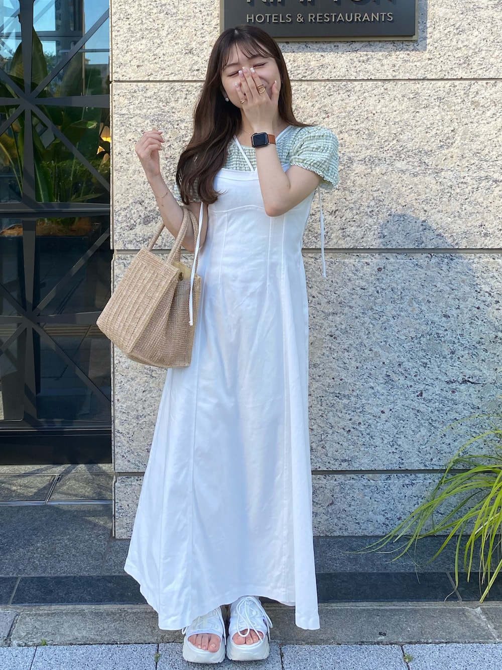 ホワイト系のサンダル、ホワイト系のワンピース、ベージュ系のトートバッグを着用したレディースの夏コーディネートの2枚目の写真