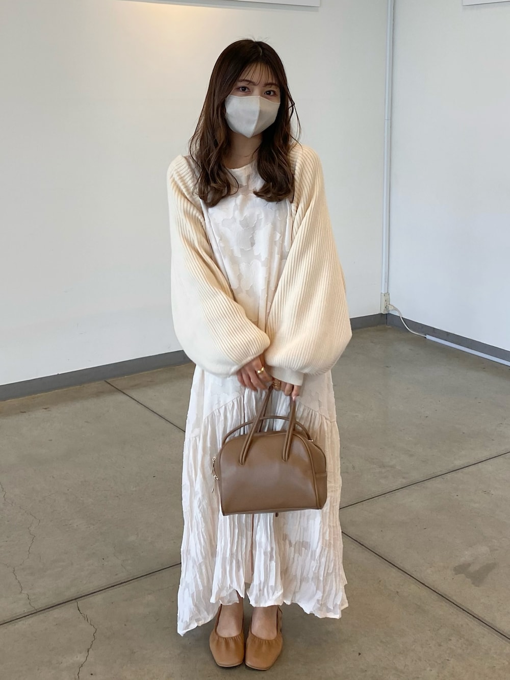 ブラウン系のバッグ、ホワイト系のカーディガン/ボレロ、ブラウン系のドレスシューズを着用したレディースの春コーディネートの2枚目の写真