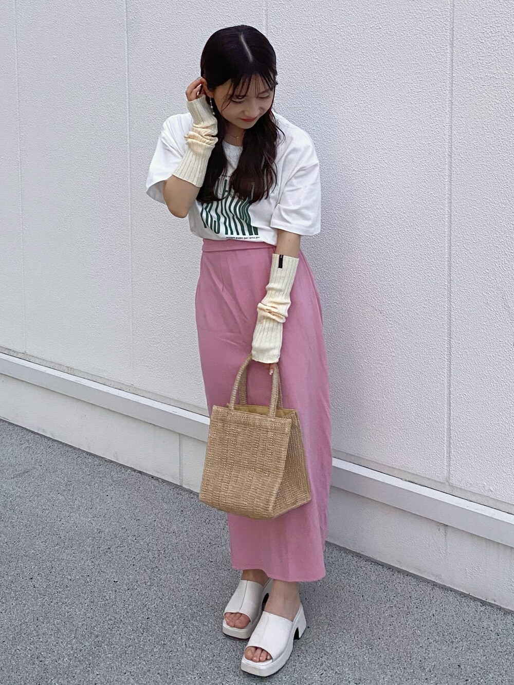 ベージュ系のトートバッグ、ピンク系のスカート、ホワイト系のサンダルを着用したレディースの夏コーディネートの3枚目の写真