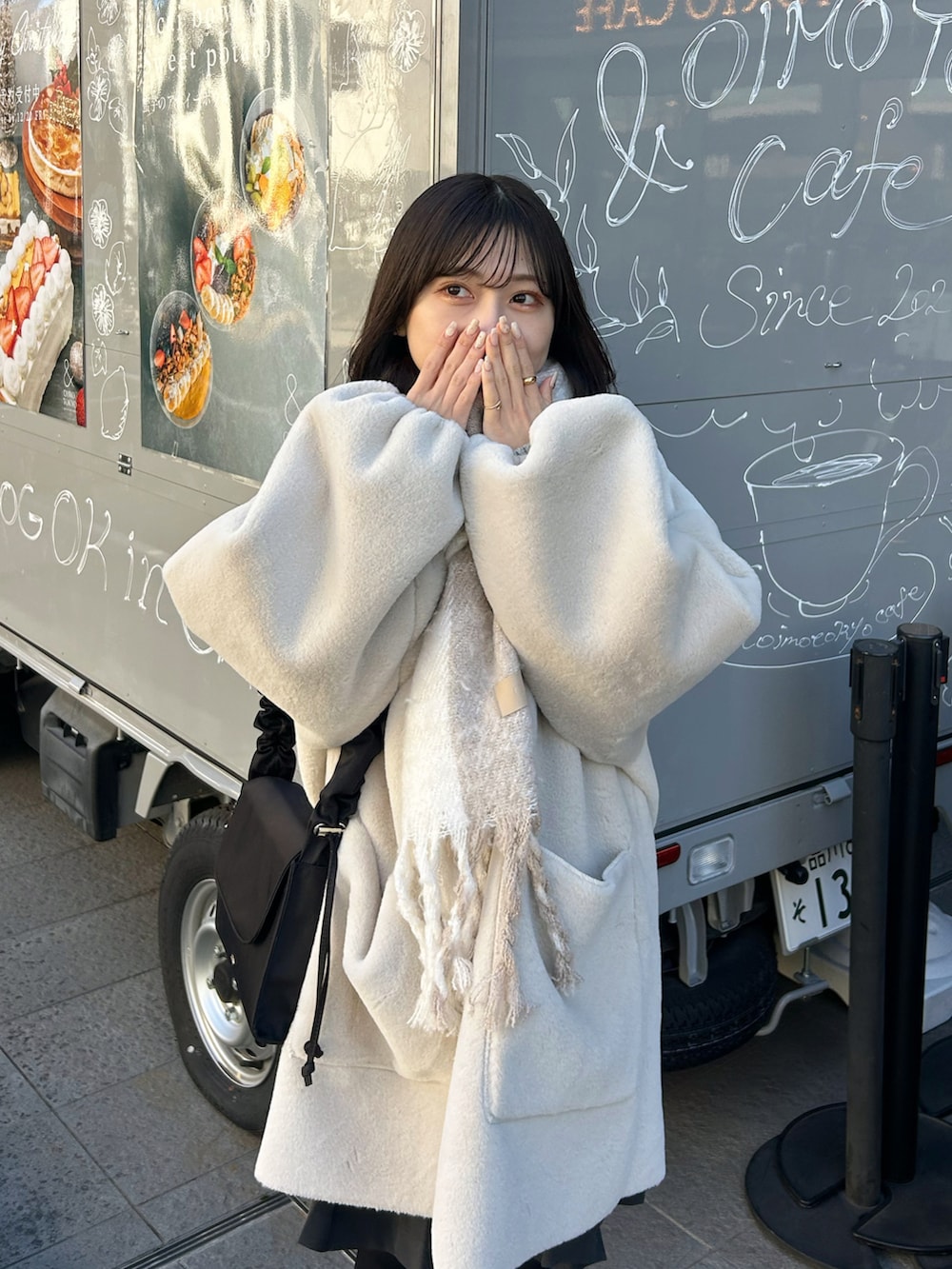 ブラック系のバッグ、ベージュ系のブーツ、ホワイト系のその他アウターを着用したレディースの冬コーディネートの4枚目の写真