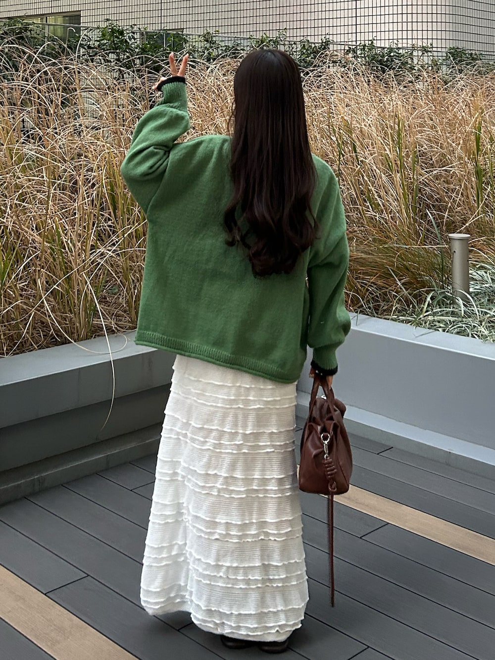 ブラウン系のボストンバッグ、ベージュ系のダッフルコート、ブラウン系のブーツを着用したレディースの冬コーディネートの3枚目の写真