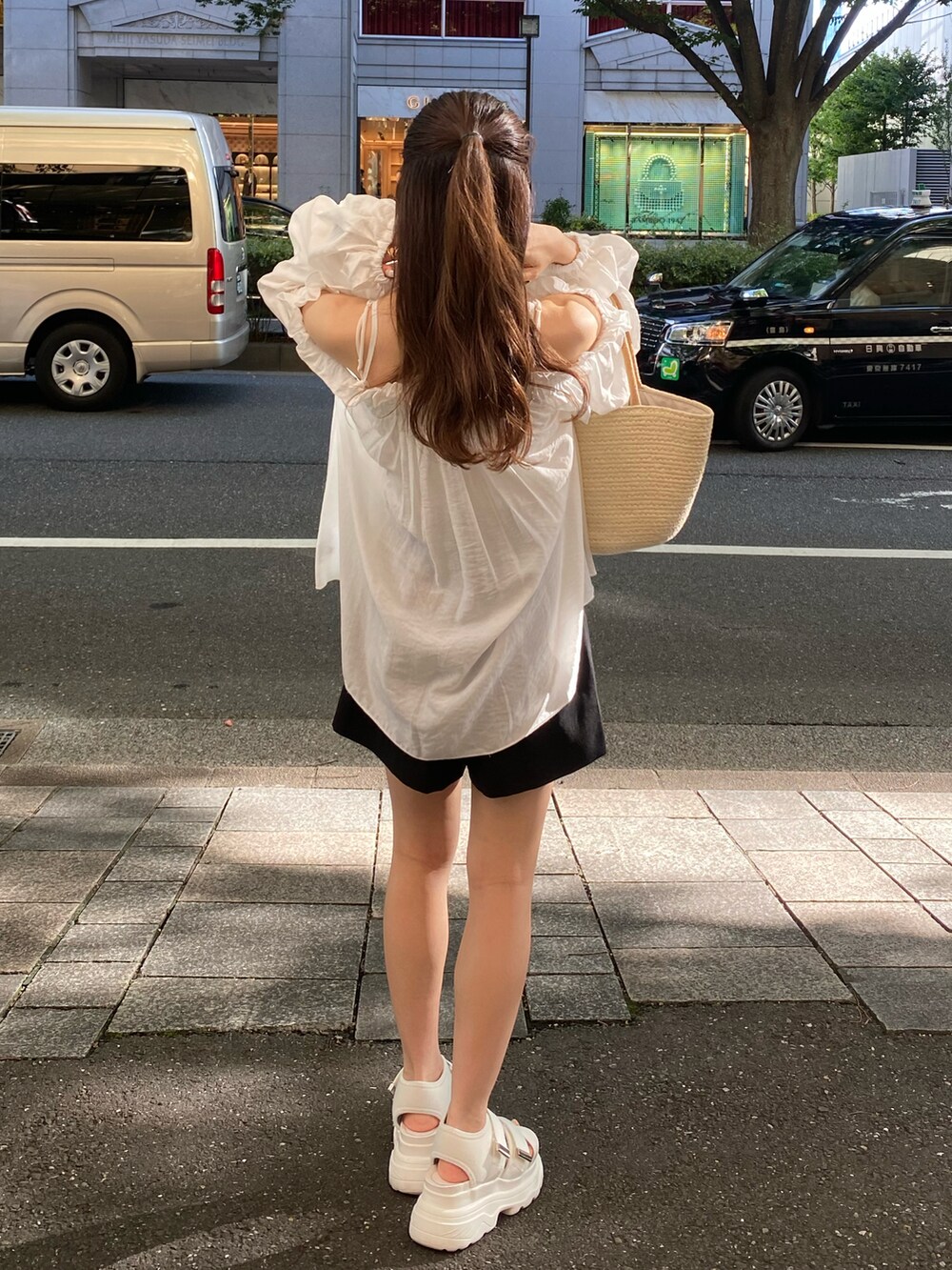 ホワイト系のサンダル、ベージュ系のトートバッグ、ホワイト系のシャツ/ブラウスを着用したレディースの夏コーディネートの2枚目の写真