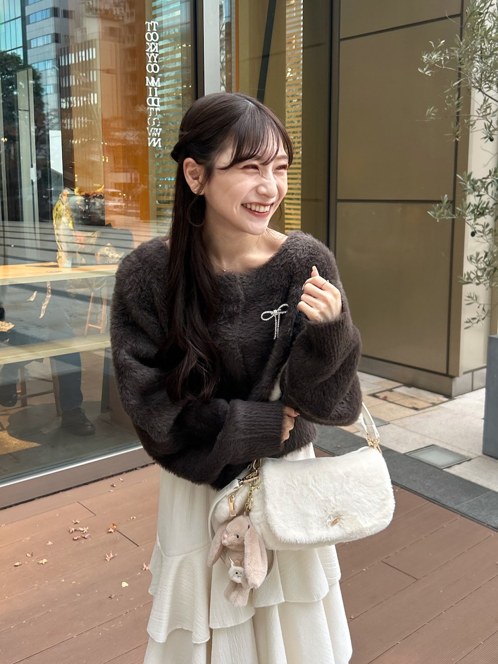 ホワイト系のショルダーバッグ、ピンク系のワンピース、ブラウン系のカーディガン/ボレロを着用したレディースの冬コーディネートの2枚目の写真