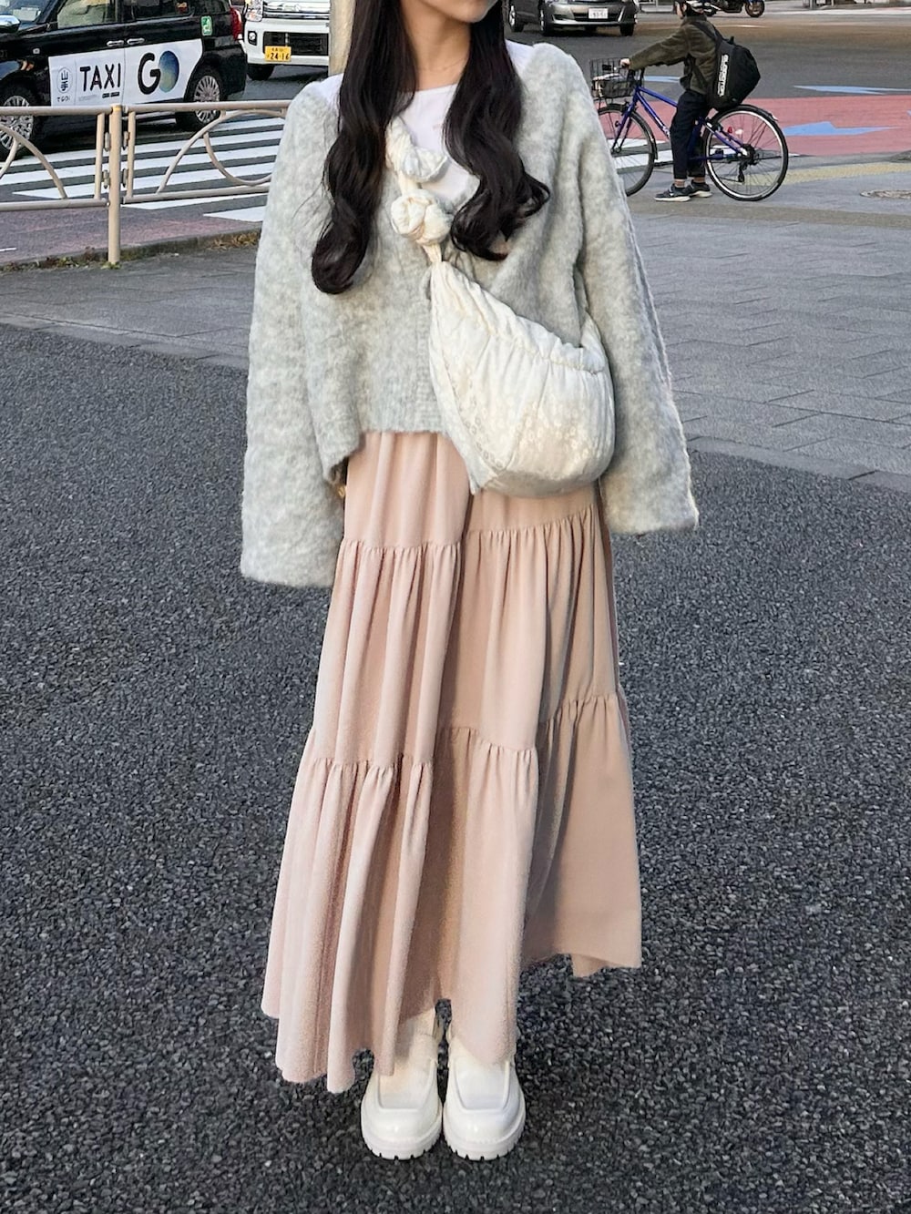 グレー系のカーディガン/ボレロ、ホワイト系のスカート、ホワイト系のトップスを着用したレディースの春コーディネートの3枚目の写真