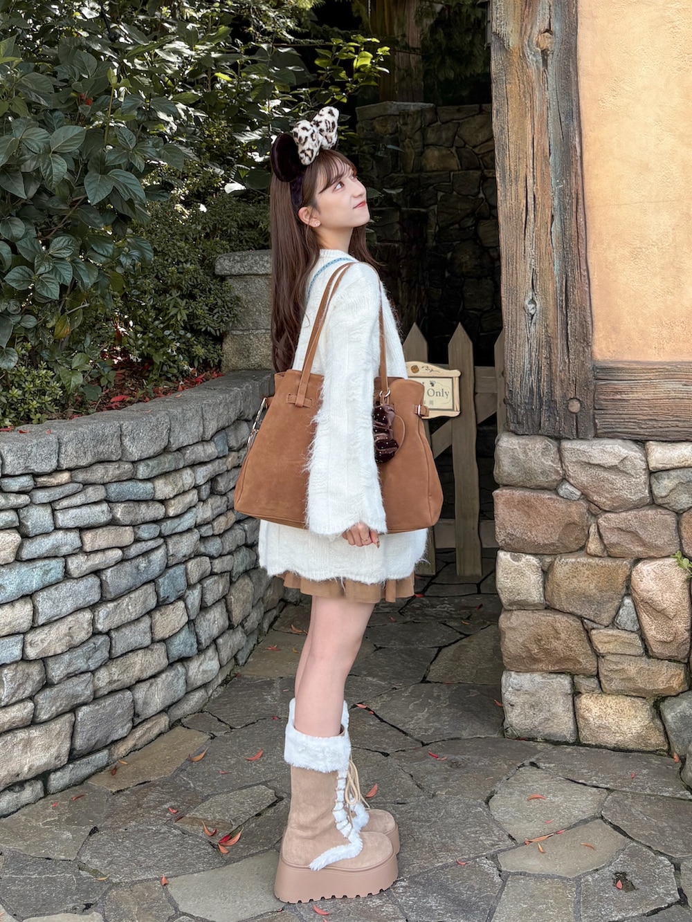 ホワイト系のニット/セーター、ブラウン系のトートバッグ、ベージュ系のスカートを着用したレディースの秋コーディネートの2枚目の写真