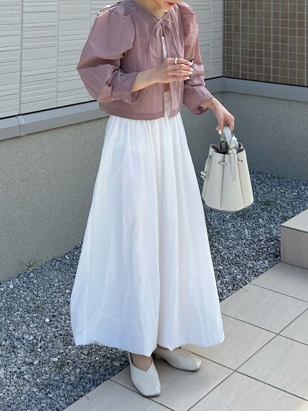 ホワイト系のバッグ、ピンク系のシャツ/ブラウス、ホワイト系のチューブトップを着用したレディースの春コーディネートの4枚目の写真