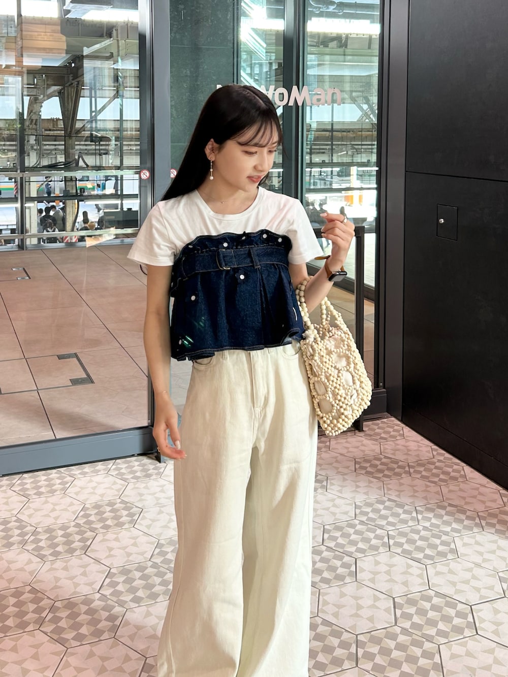 ホワイト系のハンドバッグ、ホワイト系のその他パンツ、ホワイト系のTシャツ/カットソーを着用したレディースの夏コーディネートの3枚目の写真