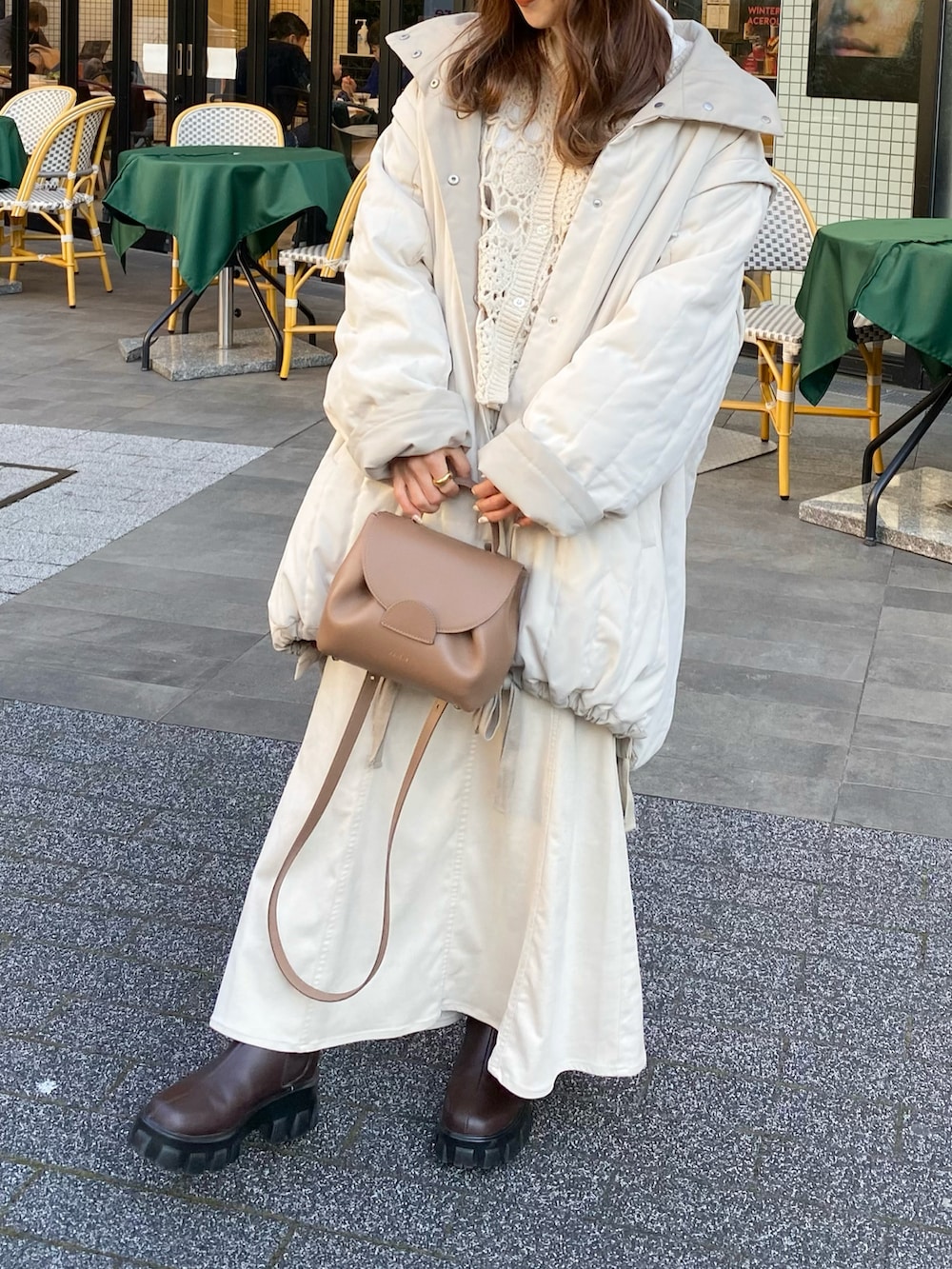 ホワイト系のダウンジャケット/コート、ブラウン系のバッグ、ブラウン系のブーツを着用したレディースの冬コーディネートの3枚目の写真