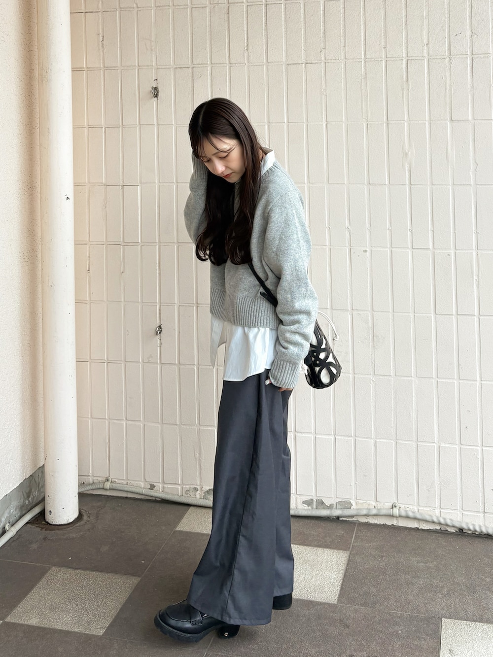 ブラック系のシューズ、グレー系のニット/セーター、ホワイト系のシャツ/ブラウスを着用したレディースの春コーディネートの3枚目の写真