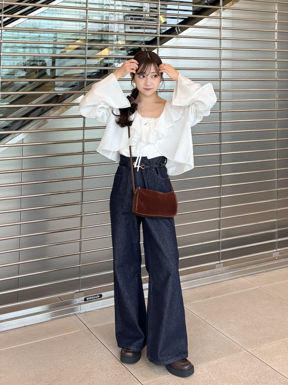 ブルー系のデニムパンツ、ブラウン系のローファー、ホワイト系のシャツ/ブラウスを着用したレディースの秋コーディネートの2枚目の写真