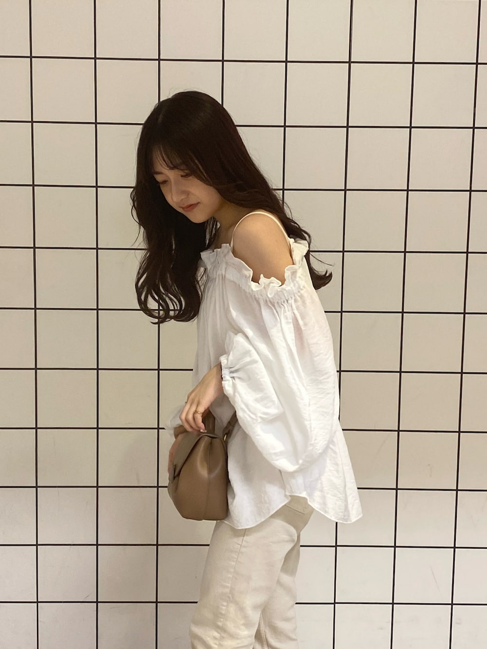 ホワイト系のサンダル、ホワイト系のデニムパンツ、ブラウン系のバッグを着用したレディースの夏コーディネートの3枚目の写真