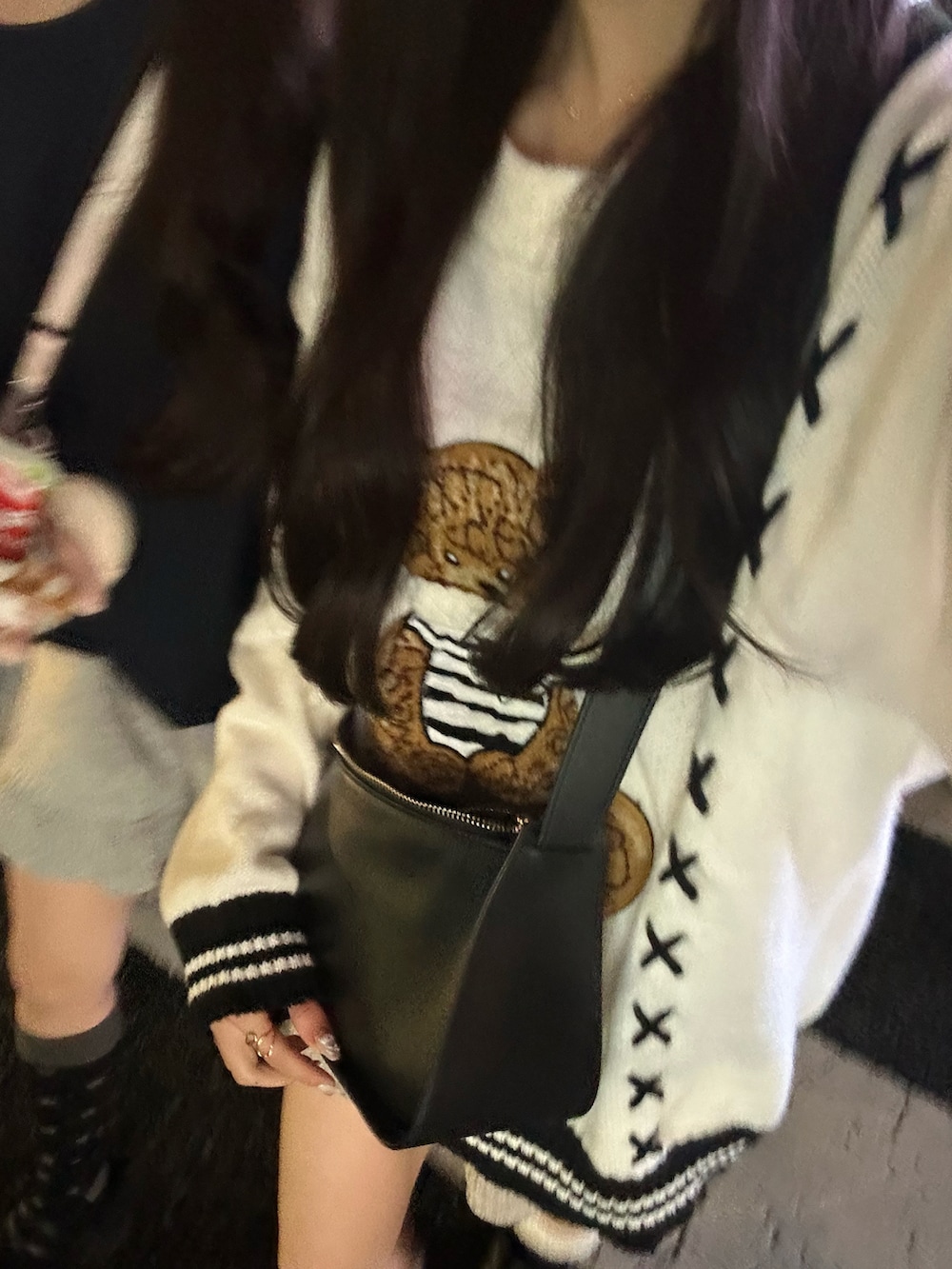 ホワイト系のニット/セーター、ブラック系のショルダーバッグ、ベージュ系のパンツを着用したレディースの秋コーディネートの4枚目の写真