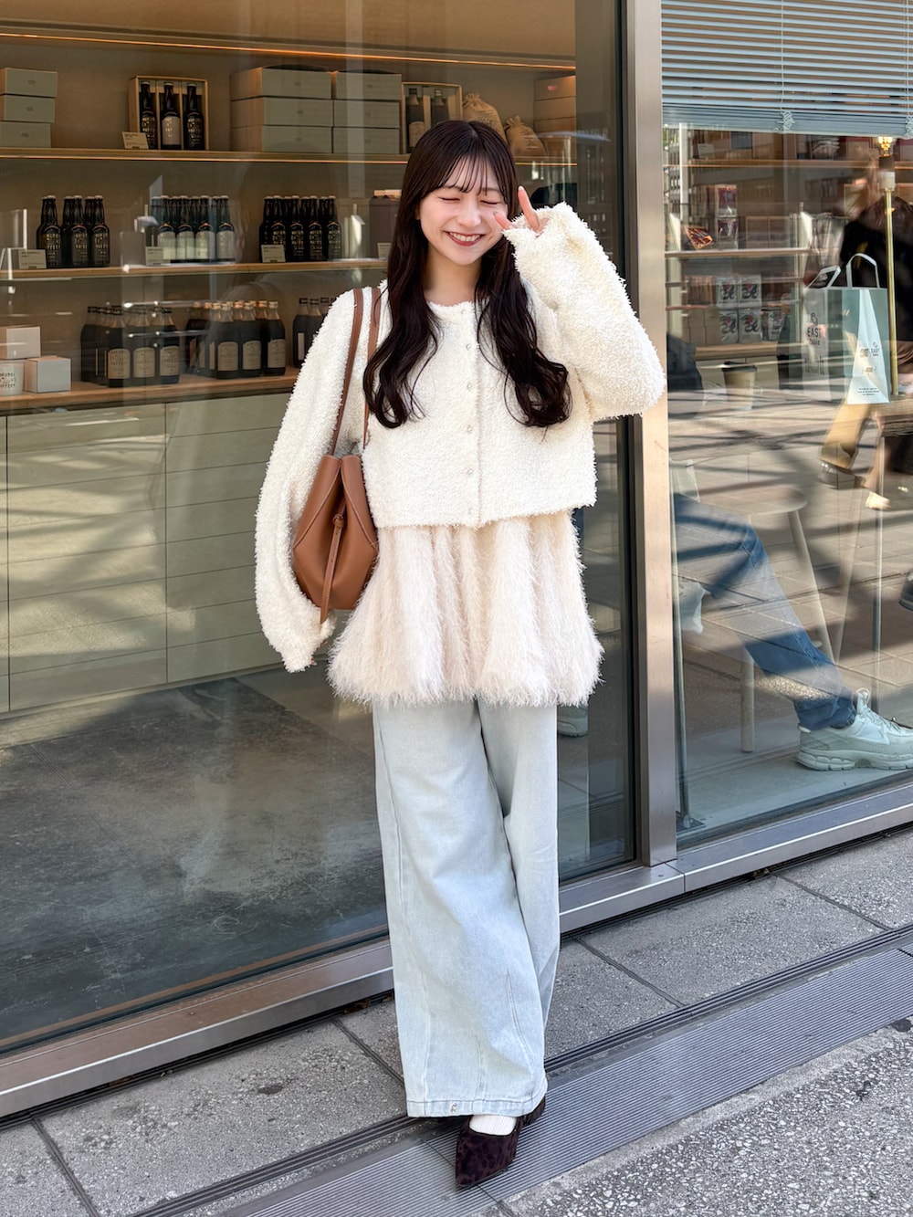 ホワイト系のキャミソール、ホワイト系のカーディガン/ボレロ、ブルー系のデニムパンツを着用したレディースの春コーディネートの4枚目の写真