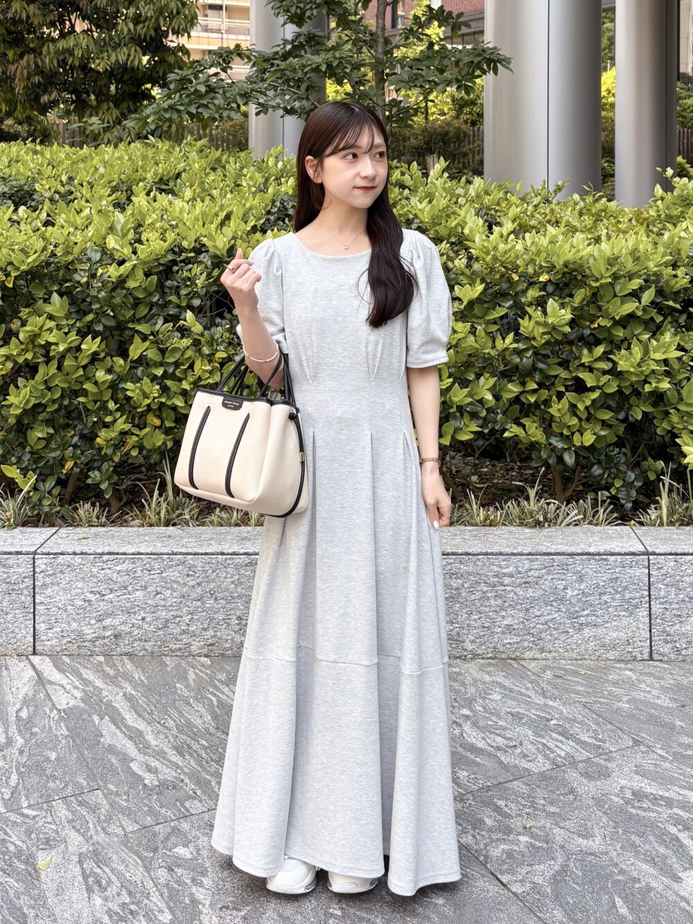 グレー系のワンピース、ホワイト系のトートバッグを着用したレディースの春コーディネートの2枚目の写真