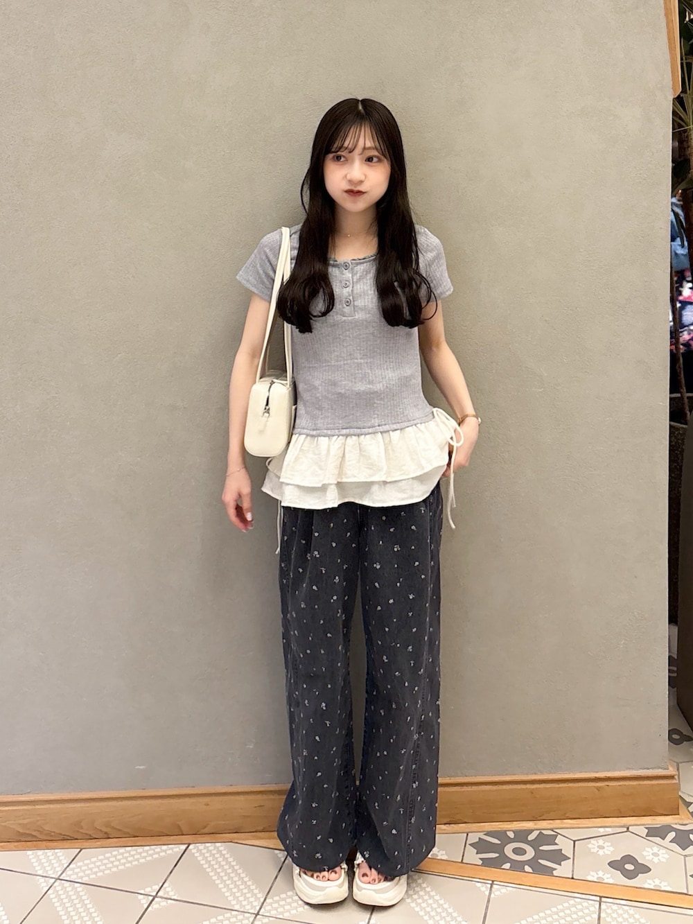 グレー系のTシャツ/カットソー、ホワイト系のショルダーバッグ、ブラック系のデニムパンツを着用したレディースの春コーディネートの4枚目の写真