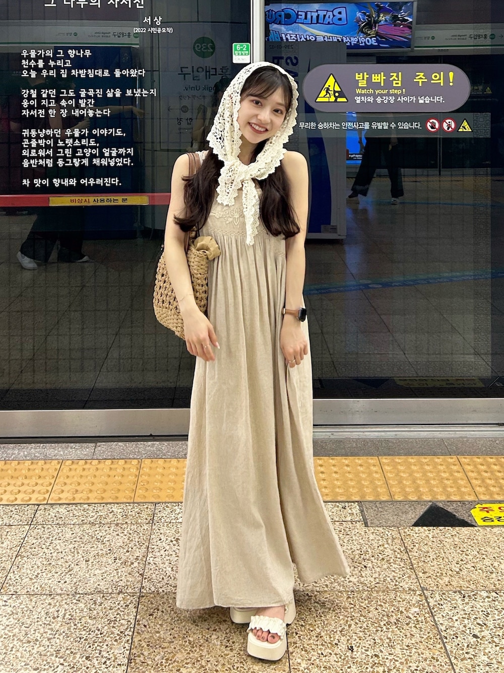 ベージュ系のワンピース/ドレス、ブラウン系のかごバッグ、ホワイト系のサンダルを着用したレディースの夏コーディネートの3枚目の写真