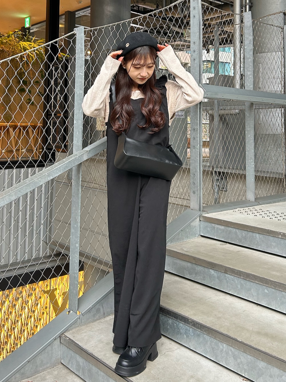 ブラック系のシューズ、ブラック系のショルダーバッグ、ブラック系のつなぎ/オールインワンを着用したレディースの冬コーディネートの4枚目の写真