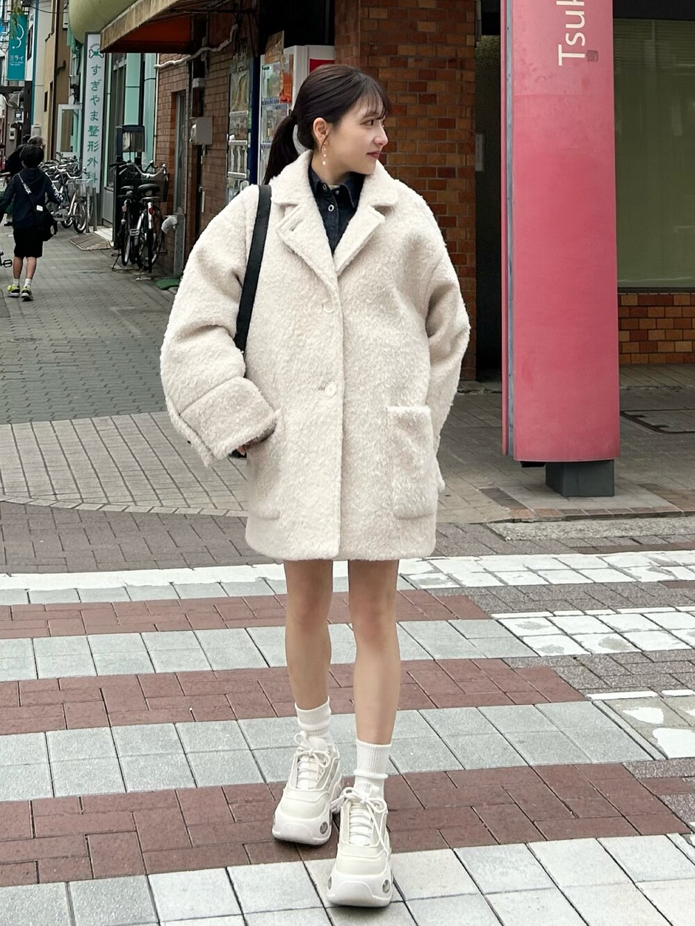 ホワイト系のその他アウター、ブラック系のショルダーバッグ、ホワイト系のスニーカーを着用したレディースの春コーディネートの2枚目の写真