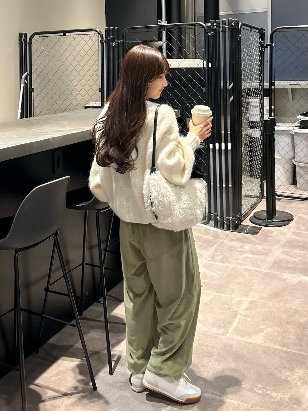 グリーン系のその他パンツ、ホワイト系のニット/セーター、ホワイト系のショルダーバッグを着用したレディースの冬コーディネートの3枚目の写真