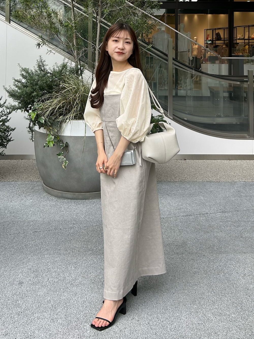 グレー系のワンピース、シルバー系のショルダーバッグ、ブラック系のサンダルを着用したレディースの夏コーディネートの3枚目の写真