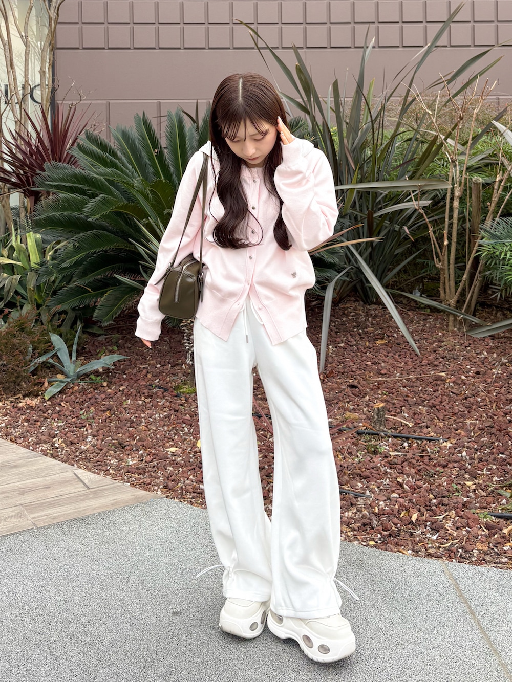 ホワイト系のスウェットパンツ、ピンク系のカーディガン/ボレロ、グリーン系のトートバッグを着用したレディースの春コーディネートの4枚目の写真